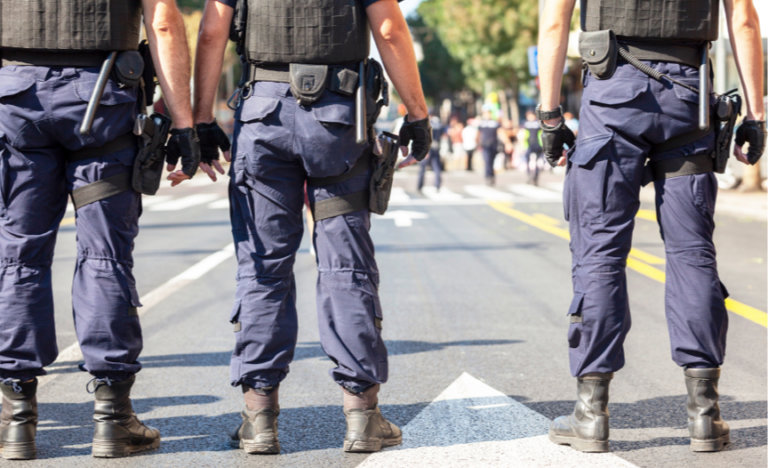 Police standing in front of oncoming protest march.