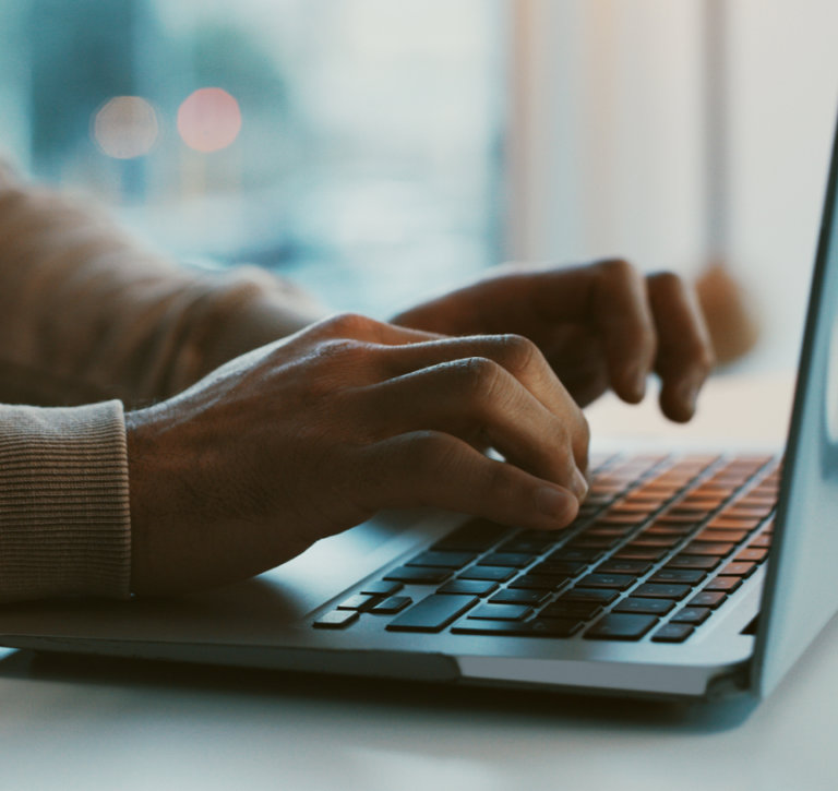 Close up on person typing on laptop.